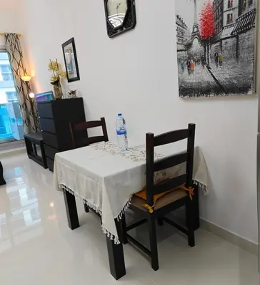 a dining room table with two chairs and a bottle of water on it at Luxury Studio Apartment in the beautiful Dubai in Dubai