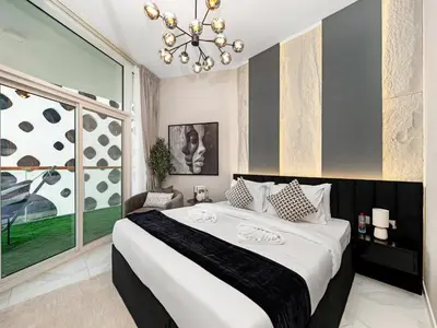 a bedroom with a large bed and a chandelier at Stunning Burj Khalifa & Lake View 2BR with GYM and Pool in Dubai