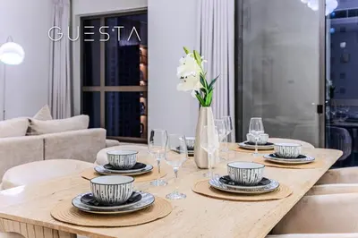 a wooden table with plates and wine glasses on it at Jumeirah Beach Residence - Murjan 5, Dubai Marina in Dubai