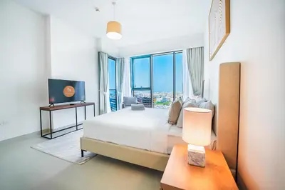 a bedroom with a bed and a large window at Elegant 2 M with Direct Canal & Iconic View in Dubai