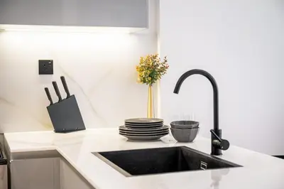 a kitchen counter with a sink and plates and aaucet at Burj Khalifa View-Beautiful Pool-Gym-Business Bay in Dubai