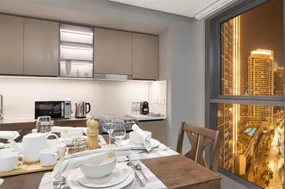 a kitchen with a dining table with a view of a city at BURJ CROWN - Elegant & Spacious Two-Bedroom Apartment in Downtown Dubai, Just 10 Minutes' Walk from Dubai Mall & Dubai Fountains, Surrounded by Iconic Landmarks in Dubai