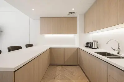 a kitchen with wooden cabinets and a sink at Daniels 2BR with Maid Room at Liv Residency with Marina View in Dubai
