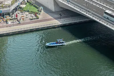 a small boat in the water under a bridge at Daniels 2BR with Maid Room at Liv Residency with Marina View in Dubai