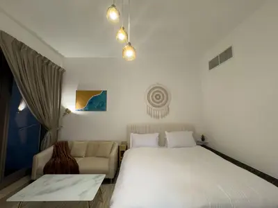 a bedroom with a large bed and a couch at Studio Apartment in Sparkle Tower Dubai Marina in Dubai
