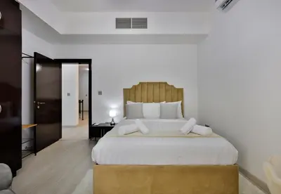 a bedroom with a large bed with a wooden headboard at 5BR & Maids Room with Private Pool in The Aldea, The Villa - Allsopp & Allsopp in Dubai
