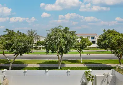 a street with trees in front of a building at 5BR & Maids Room with Private Pool in The Aldea, The Villa - Allsopp & Allsopp in Dubai