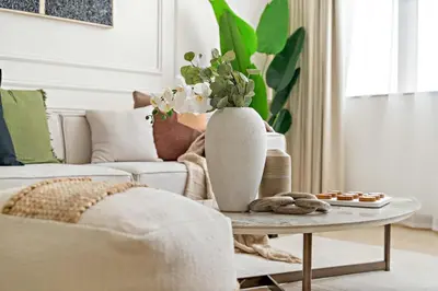 a living room with a couch and a table with a vase at Silkhaus Comfy 1BDR at Sky Gardens in DIFC-NEW in Dubai