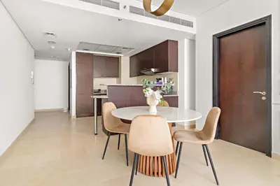 a kitchen and dining room with a table and chairs at Silkhaus Comfy 1BDR at Sky Gardens in DIFC-NEW in Dubai