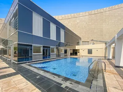 a large building with a swimming pool in front of it at Silkhaus Luxury Studio at Sky Gardens in DIFC Views in Dubai