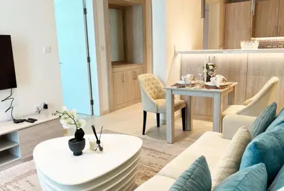 a living room with a couch and a table at Spacious 1 bed with seaview in Seven Palm - Palm Jumeirah - IQPRO Holidays in Dubai