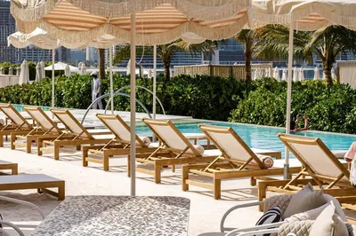 a row of lounge chairs next to a swimming pool at Spacious 1 bed with seaview in Seven Palm - Palm Jumeirah - IQPRO Holidays in Dubai
