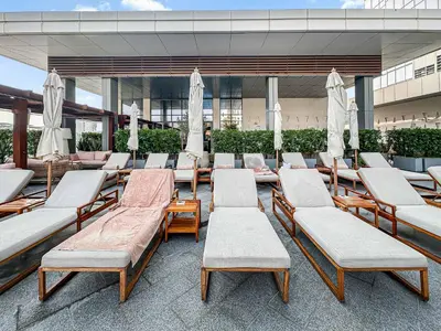 a group of lounge chairs and umbrellas in a building at NEW Luxury studio - Amazing Palm Views in Dubai
