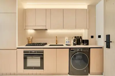 a kitchen with a dishwasher and a washer at Chic Studio in Dawn by Binghatti, Heart of JVC in Dubai