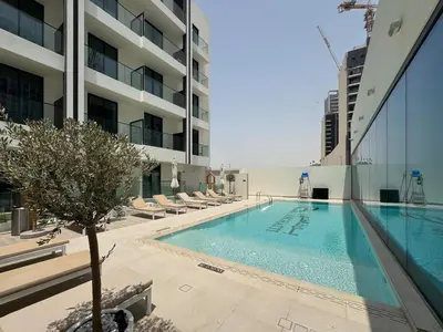 a swimming pool on the side of a building at Chic Studio in Dawn by Binghatti, Heart of JVC in Dubai