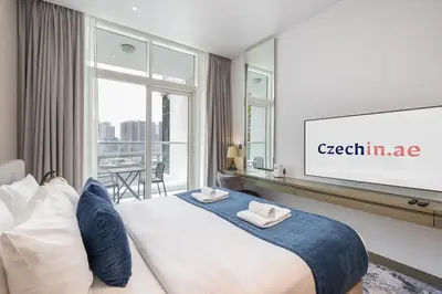 a hotel room with a large bed and a projection screen at Chic Canal-ViewStudio by Czechin Pool & Gym Access in Dubai