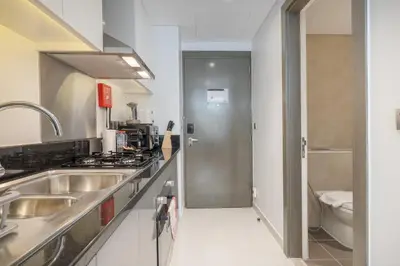 a kitchen with a sink and a toilet at Chic Canal-ViewStudio by Czechin Pool & Gym Access in Dubai
