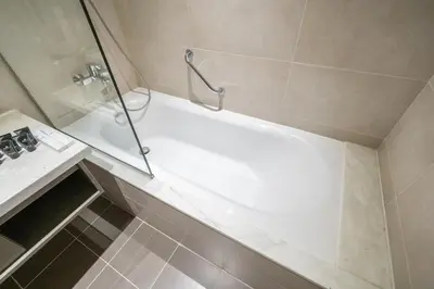 a bathroom with a shower and a bath tub at Chic Canal-ViewStudio by Czechin Pool & Gym Access in Dubai