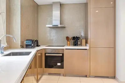 a kitchen with wooden cabinets and a sink at BLVD - Luxury Stay with Burj Khalifa View in Dubai