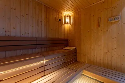 a wooden sauna with a light on the inside at 2BDR with Pool, Sauna and PS5 - Near Circle Mall in Dubai