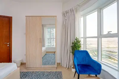 a bathroom with a blue chair and a mirror at Modern 1BR with City View - Balcony - Near Metro in Dubai