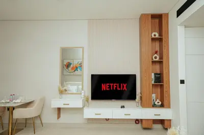 a living room with a tv in a white cabinet at Apt in Trillionaire Residences with Private Jacuzzi in Dubai