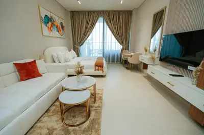 a living room with a white couch and a tv at Apt in Trillionaire Residences with Private Jacuzzi in Dubai