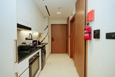 a small kitchen with a stove and a door at Apt in Trillionaire Residences with Private Jacuzzi in Dubai