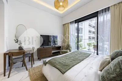 a bedroom with a bed and a desk and a window at Bloomfields Supreme Stu In Azizi Riviera in Dubai