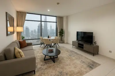 a living room with a couch and a tv and a table at DIFC Index Tower Burj Khalifa View 1BR in Dubai