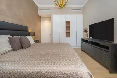 a bedroom with a large bed and a flat screen tv at Port de la Mer Luxury Sleeps 4Person in Dubai