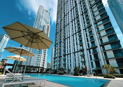 a pool with two chairs and an umbrella and a building at Luxury Burj Crown Suites by Maison Aurora in Dubai