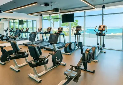 a gym with a lot of treadmills and machines at Serene Ocean Views 2BR Emaar Beachfront in Dubai