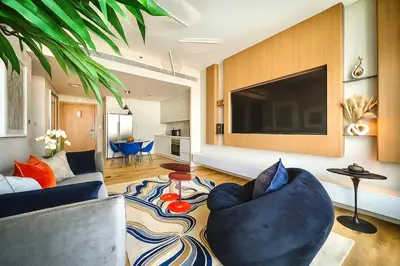 a living room with a blue couch and a large tv at Serene Ocean Views 2BR Emaar Beachfront in Dubai