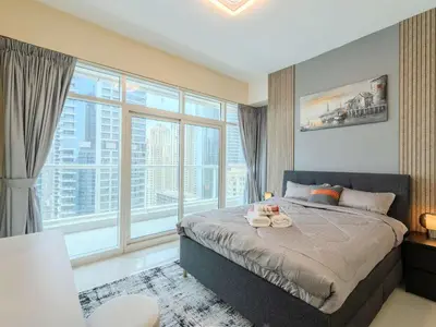 a bedroom with a large bed with a large window at Continental Tower Luxury 2BR Dubai Marina Views in Dubai