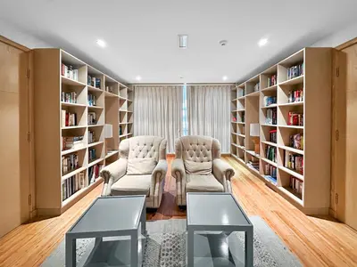 a library with two chairs and bookshelves at Stunning 2 Bdr Luxury Burj Khalifa view in Dubai