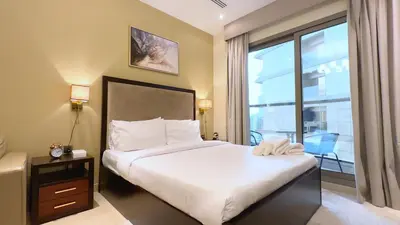 a bedroom with a bed and a large window at Elite Residency- A Cosy Studio in Downtown in Dubai