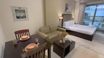 a living room with a couch and a bed and a table at Elite Residency- A Cosy Studio in Downtown in Dubai