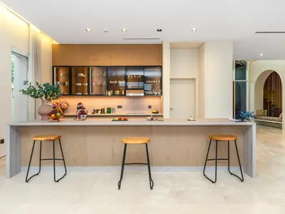 a kitchen with two bar stools and a counter at Dubai Hills Mansion Cinema, Gym & Luxe Pool in Dubai