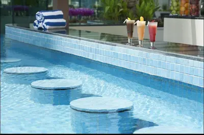 a swimming pool with four stoppers in the water at Luxury Studio with Pool, Gym & Downtown Access in Dubai
