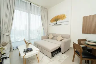 a living room with a white couch and a table at Binghatti Amber in JVC, 15 Min to Marina in Dubai