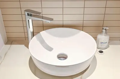 a white toilet in a bathroom with a sink at Modern 1BR w Balcony & Great Amenities JVC in Dubai
