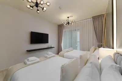 a hotel room with two beds and a flat screen tv at Large Flat in High Floor with view to Marina Canal & Beach sleep 8px in Dubai