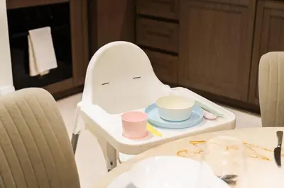 a high chair with a plate and cups on it at SettlerHomes - 14F Ocean View Gem With Private Beach in Dubai