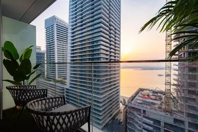 a balcony with two chairs and a view of a city at SettlerHomes - 14F Ocean View Gem With Private Beach in Dubai