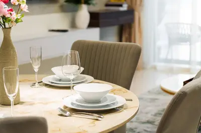 a wooden table with plates and wine glasses on it at SettlerHomes - 14F Ocean View Gem With Private Beach in Dubai