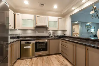 a kitchen with stainless steel appliances and wooden cabinets at Spacious 2 bedroom apartment I Palm Jumeirah in Dubai