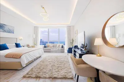 a bedroom with a bed and a desk and a mirror at Sky-High Elegant Suite at Palm Tower in Dubai
