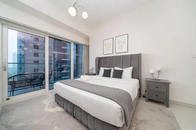 a bedroom with a large bed and a large window at High-Floor Elegance | 1-Bedroom with Marina Views in Dubai