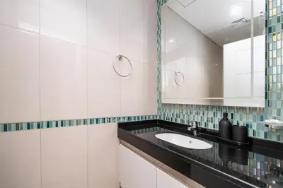 a bathroom with a sink and a mirror at High-Floor Elegance | 1-Bedroom with Marina Views in Dubai
